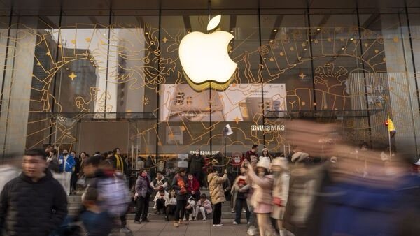 Shoppers pass an Apple Inc. store on East Nanjing Road in Shanghai, China, on Sunday, Feb. 11, 2024. Just over a year after China ended its Covid-Zero policy, the expected bounceback in spending on high-end consumer goods has failed to live up to expectations. Photographer: Raul Ariano/Bloomberg